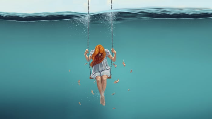 Girl on a swing underwater with fish