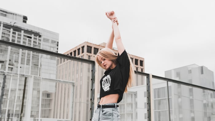 Girl with arms raised on a rooftop