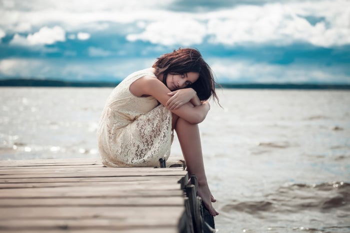 Woman with short hair sitting on a dock