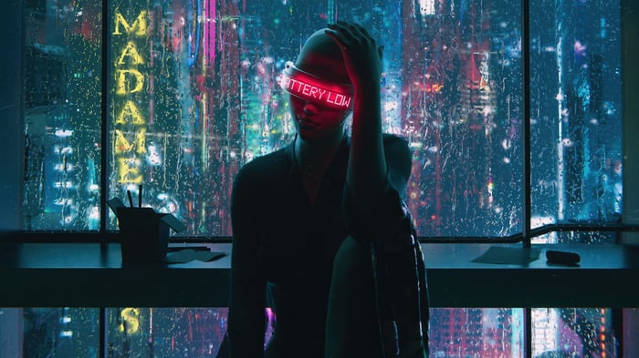 Person with "BATTERY LOW" visor in a rainy city
