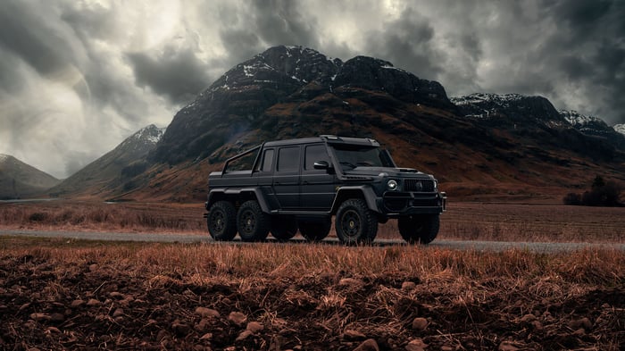 Black Mercedes-AMG G 63 6x6 on a road with mountains