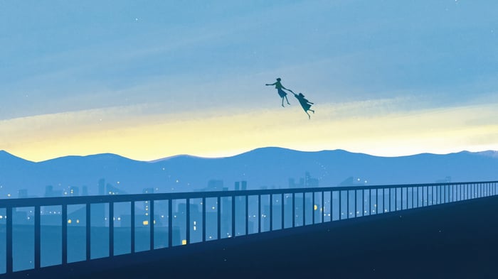 Two figures flying over a city at dusk