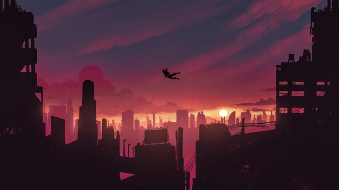 Silhouette falling against a sunset cityscape