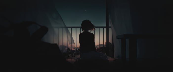 Silhouette of a person on a balcony at night