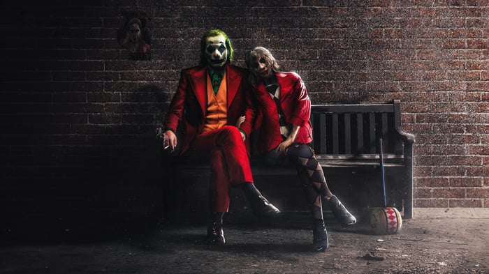 Joker and Harley Quinn sitting on a bench