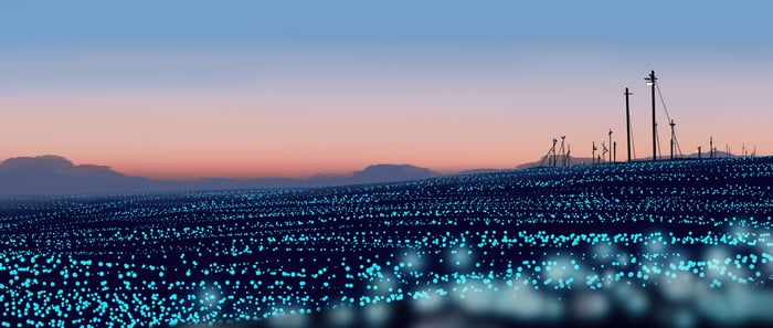Glowing field with power lines at sunset
