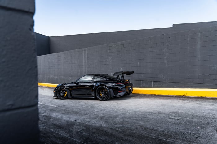 Black Porsche 992 GT3 RS parked by a wall