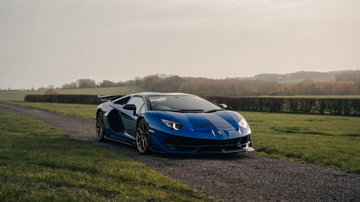 Blue Lamborghini Aventador SVJ on a gravel road