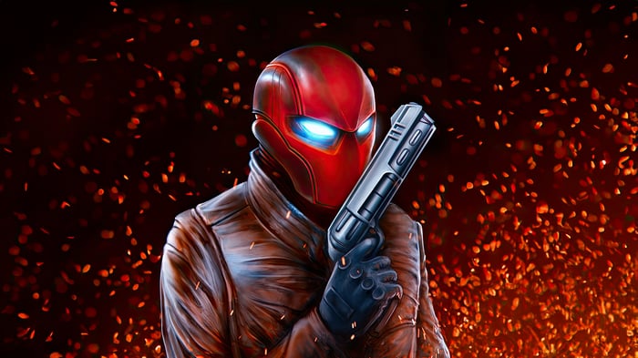 Red Hood holding a gun with sparks in the background