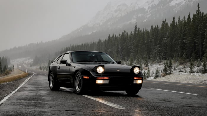 Black 1986 Porsche 944 Turbo on a wet road