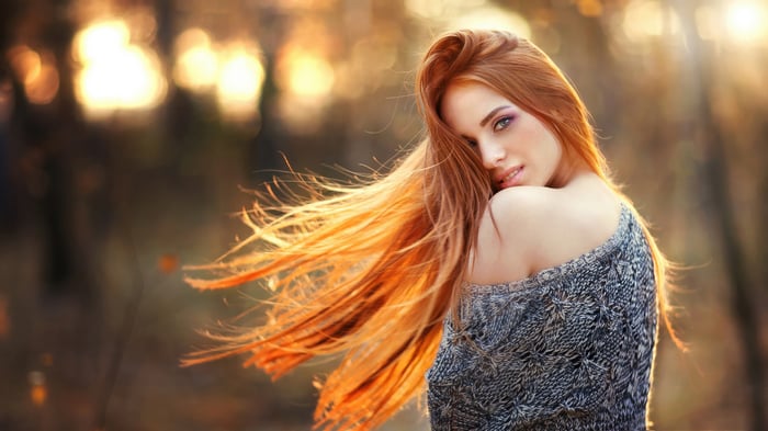 Woman with long orange hair in autumn nature