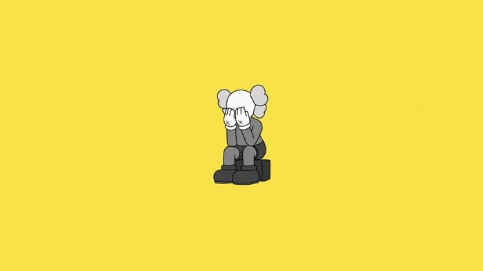 Kaws character sitting with hands over face