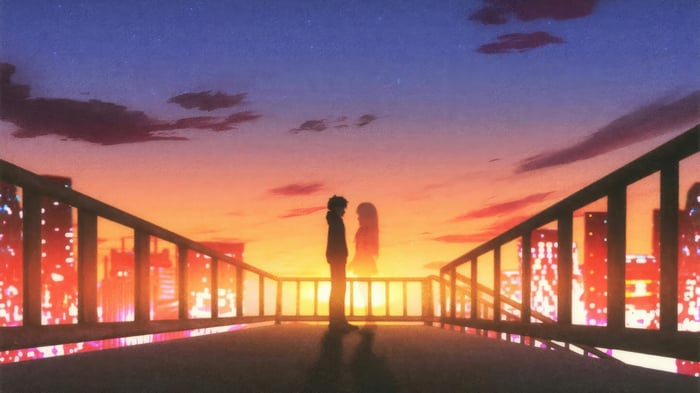 Couple Silhouetted Against a Sunset Over City