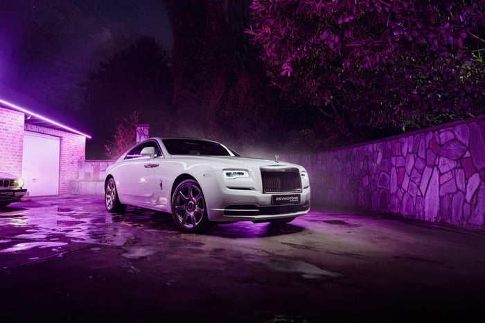 White Rolls Royce Wraith parked at night with purple lighting