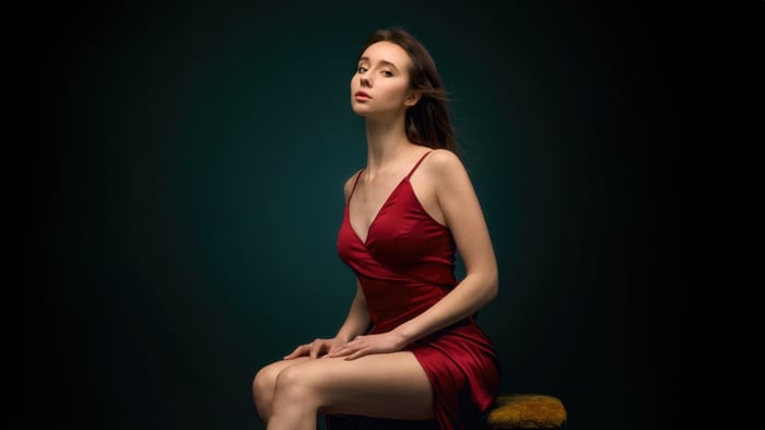 Woman in a red dress sitting on a stool