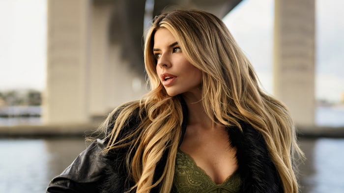 Blonde woman in lingerie and jacket under bridge