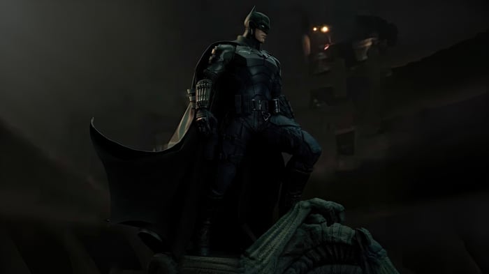 The Batman standing on a gargoyle