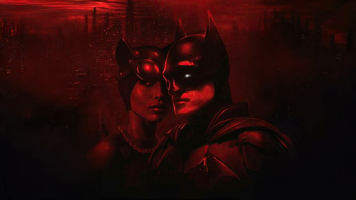Batman and Catwoman in a red-lit city