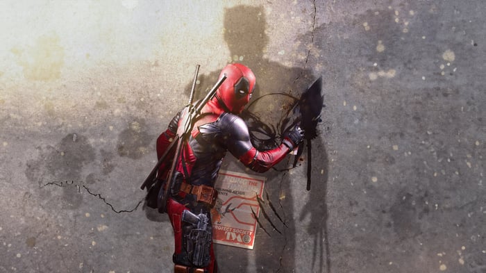 Deadpool painting a shadow of Wolverine on a wall