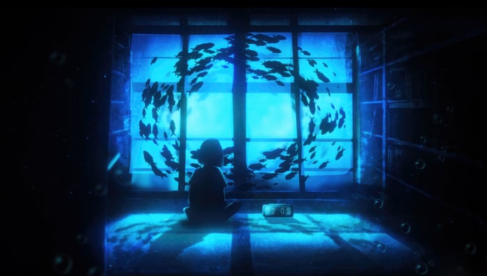 Silhouette of a child watching fish swim by a window