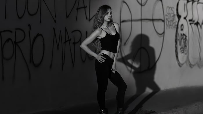 Woman Poses in Front of Graffiti Wall
