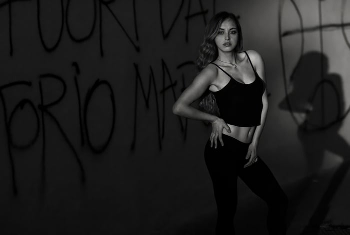 Girl in black clothing against graffiti wall