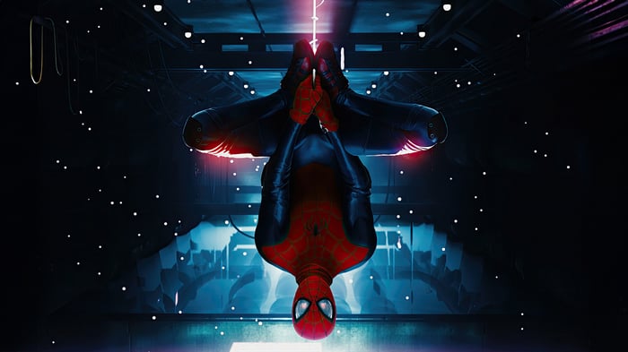 Spider-Man hanging upside down in a dark, futuristic setting
