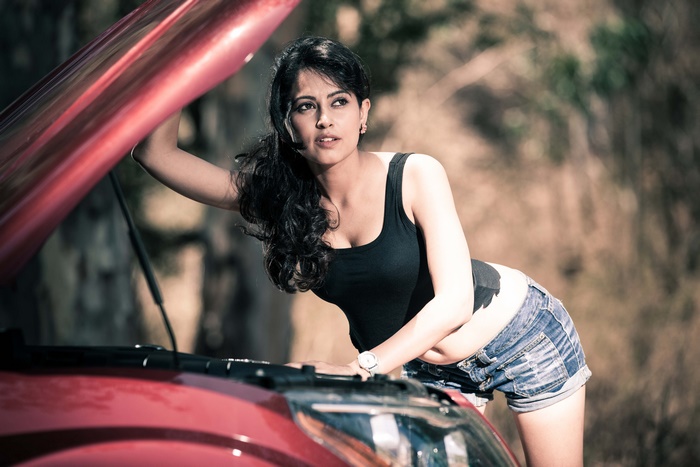 Woman with black hair looking at car engine