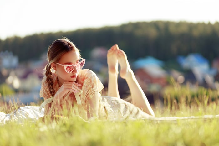 Girl in heart sunglasses lying in grass
