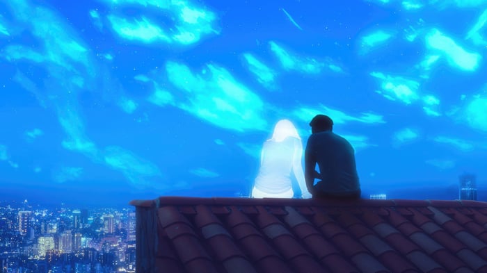 Two figures on a rooftop overlooking a city at night