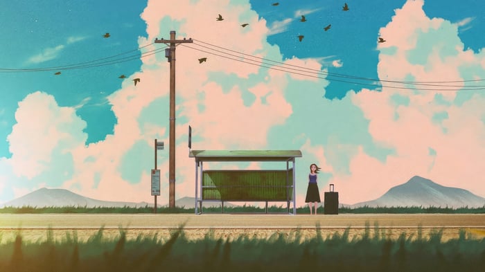 Girl with suitcase at bus stop with mountains