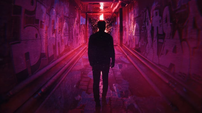 Silhouette of a person in a graffiti-covered tunnel