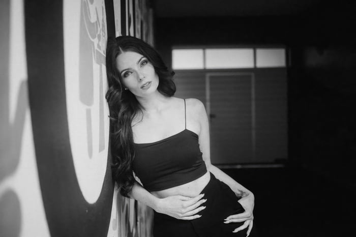 Girl leaning against a graffiti wall in black and white