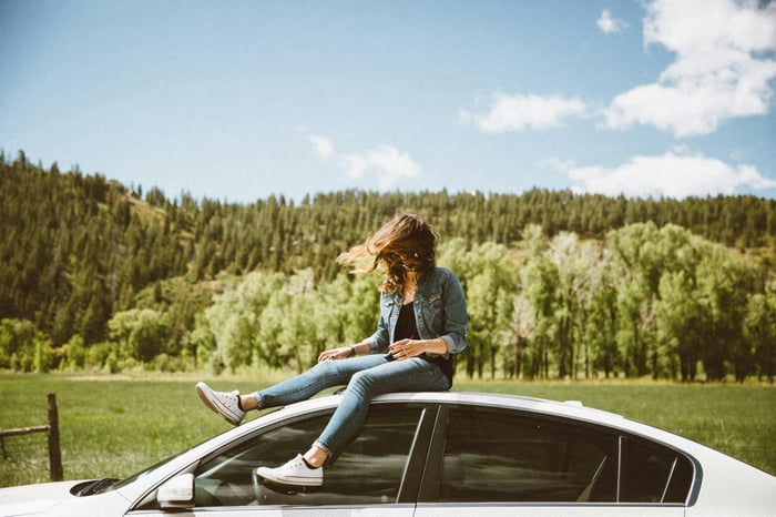 Girl Sitting on Car Roof in Nature