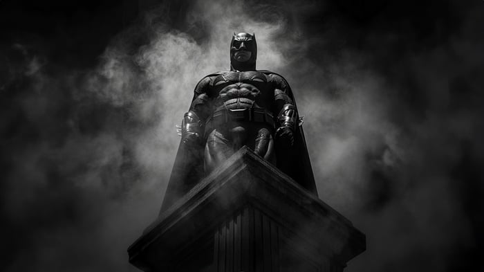 Batman standing on a pedestal in smoke