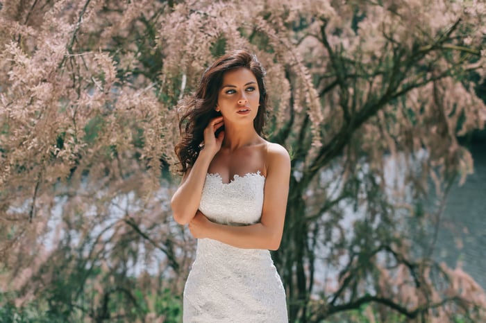 Bride in a white lace dress posing outdoors
