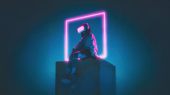 Person in VR headset sitting in neon light