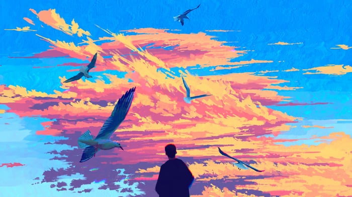 Birds flying in a colorful cloudy sky
