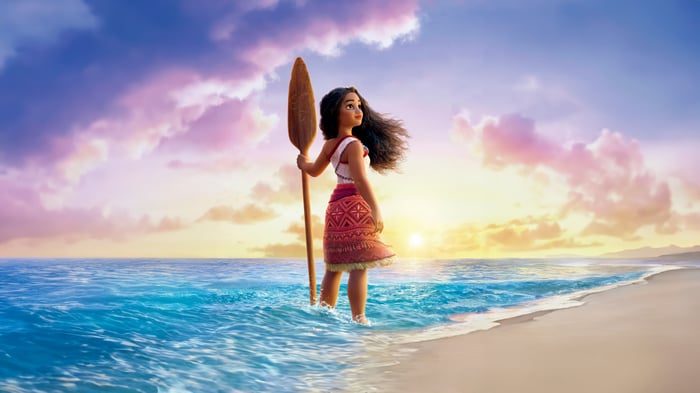 Moana standing in the ocean with a paddle