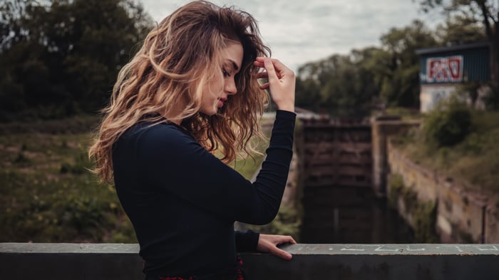 Girl playing with her curly hair outdoors