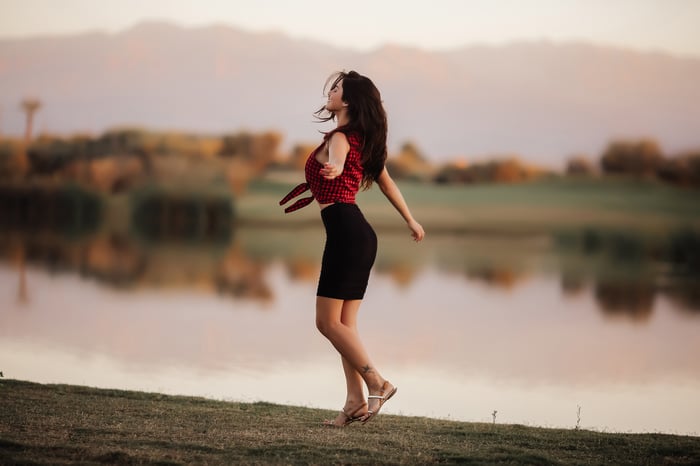 Woman dancing by a lake at sunset