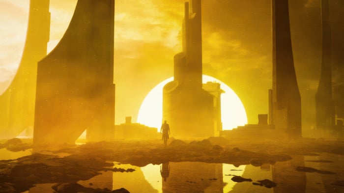 A lone figure walks through a desolate alien landscape.