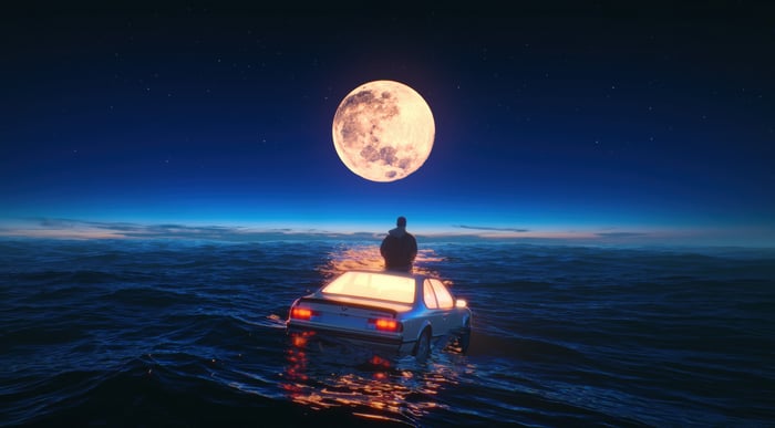 Man on car in ocean under moon