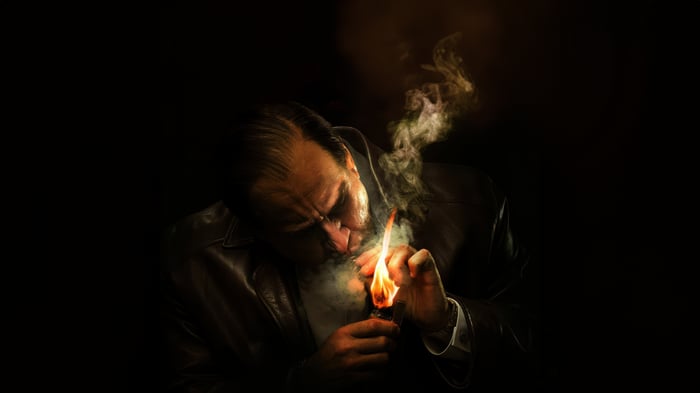The Penguin lighting a cigarette