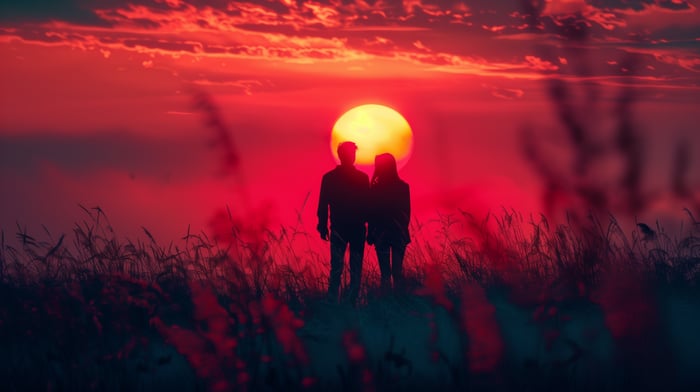 Couple silhouetted against a vibrant sunset