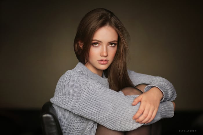 Cute Girl With Brown Hair Sitting On A Chair