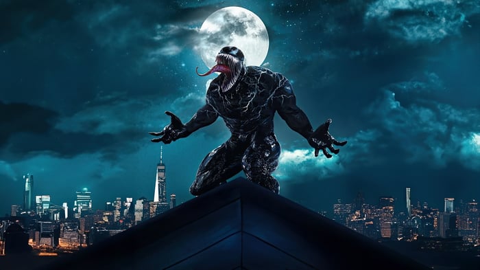 Venom on a rooftop overlooking a city at night