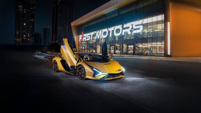 Yellow Lamborghini Sian parked in front of First Motors dealership at night