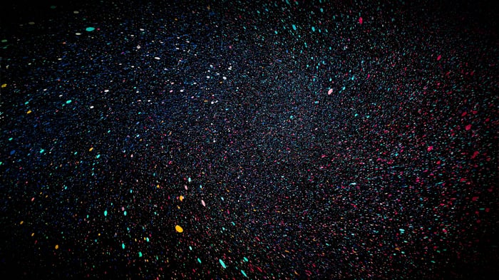 Abstract colorful dots falling on black background