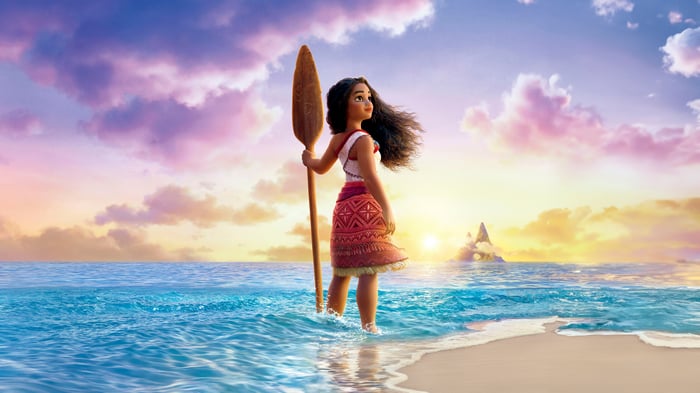 Moana standing in the ocean with a paddle